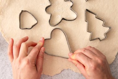 Kadın elleri şekilleri keser ve Noel kurabiyeleri yapar, evde pişirir, üst manzara....