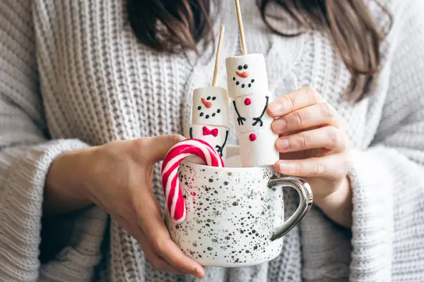 Bayramlık Noel içkisi, içinde lokum kardan adamlar ve kadınların elinde şekerler var..