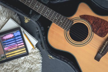 Müzik uygulaması olan akustik gitar ve dijital tablet, üst görünüm, müzik yaratma kavramı, ses kaydı.