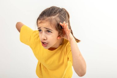 Kulağının yanında sarı tişört giyen küçük beyaz bir kız. Kulağının dibinde, kulak misafiri olduğu dedikoduları dinliyor..