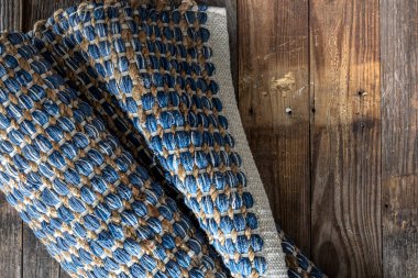 Ahşap zeminde el yapımı geometrik kot halısı, parça renkli halı, parlak hasır renkli halı..