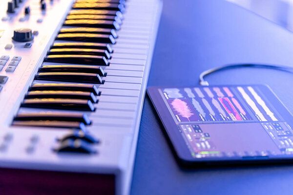 Musical keys and tablet on the table, musical application for digital tablet, music recording.