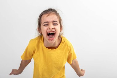 Sarı tişörtlü beyaz bir kız yüksek sesle bağırıyor, beyaz bir arka planda izole edilmiş, boşluğu kopyalıyor..