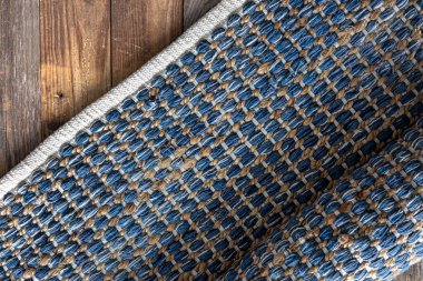 Ahşap zeminde el yapımı geometrik kot halısı, parça renkli halı, parlak hasır renkli halı..