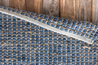 Ahşap zeminde el yapımı geometrik kot halısı, parça renkli halı, parlak hasır renkli halı..