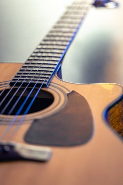 Akustik gitar, müzik aleti, koyu siyah bir zemin üzerinde dinleniyor. Ahşap klasik gitar yakın plan..