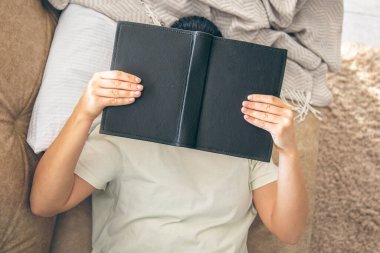 Bir kadın evinde kitap okuyor, kanepede uzanıyor, yüzünü bir kitapla örtüyor, yukarıdan bakıyor. Bir öğrenci kitap okuyor, yalnız dinleniyor..