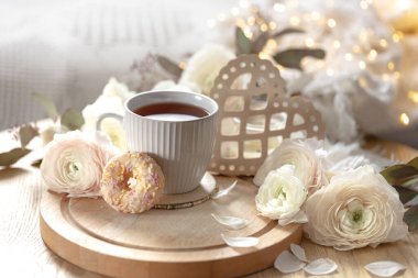 Sevgililer Günü için sıcak ev kompozisyonu çiçekler, bir fincan çay ve dekoratif kalp. Boşluğu kopyala.