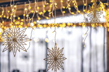 Bokeh ışıkları olan bulanık bir arka planda dekoratif kar taneleri ve çelenkler. Noel tatili dekoratif detayları iç kısımda..