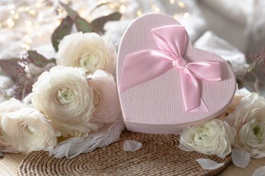 Pembe kalp şeklinde hediye kutusu ve çiçekli kompozisyon. Sevgililer Günü için hala hayat var. Boşluğu kopyala.