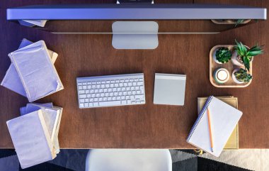 Tahta bir masanın üzerinde bilgisayar, kitap ve not defterleri olan öğrenci masası. Çevrimiçi çalışma, kendini geliştirme ve uzaktan öğrenme kavramı. Üst görünüm.