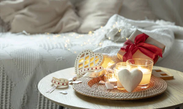 Romantic composition for Valentines Day with candles in the interior of the room. Copy space.