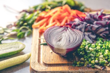 Yakın plan, yarım soğan ve salata için taze sebze. Mutfak tahtasındaki kırmızı soğan..