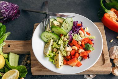 Yakın plan, mutfak masasında taze sebze salatası. Biber salatası, lahana ve salatalık. Çiğ sebze salatası, vejetaryen..