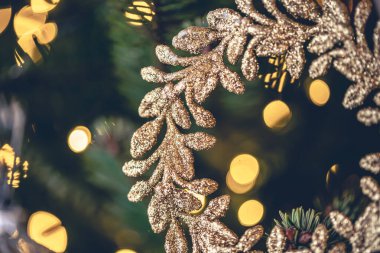 Noel ağacı dalında altın bir çelenkle süslenmiş bir Noel arkaplanı.
