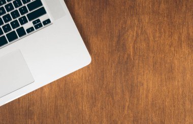 Masanın üstünde dizüstü bilgisayarı olan ahşap bir masa. Asgari çalışma alanı, çalışma masasının yaratıcı düz yatış fotoğrafı. Boşluğu kopyala.