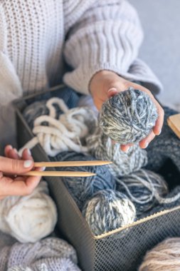 Ahşap örgü iğneleri ve dişilerin elinde bir ip yumağı. Kız hobileri için içeri giriyor. Örgü konsepti.