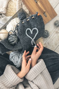 Gri iplikli ve örgü örgülü bir kadın yerde oturuyor. El yapımı giysiler. Kız hobileri için içeri giriyor. Örgü konseptine bayılırım..