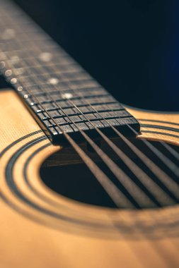 Gitar ve telleri sığ alan derinliğinde yakın çekim, yumuşak odaklanma. Profesyonel müzik enstrümanının ses deliği ve metal telleri.