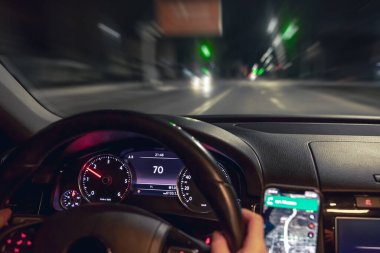 Araba direksiyonu ve gece yolu manzarası, yakın plan. Şehirde gece sürüşü.