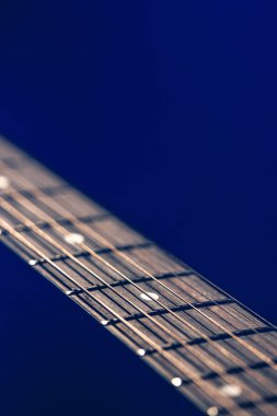 Kapat, akustik gitardaki dizgiler bulanık siyah arkaplan kopyalama alanı üzerinde.