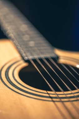 Gitar ve telleri sığ alan derinliğinde yakın çekim, yumuşak odaklanma. Profesyonel müzik enstrümanının ses deliği ve metal telleri.