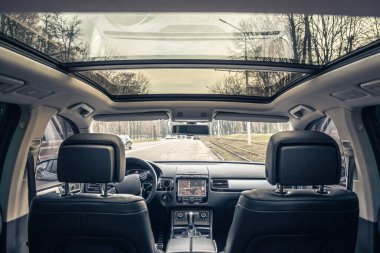 İnsansız modern bir arabanın içi, arabanın içinden bir manzara. Araba bir şehir caddesinde park halinde..