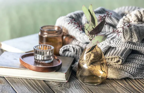 Mumlu ev kompozisyonu, ahşap bir yüzeye örülmüş elementler ve kitaplar. Kırsal biçim.