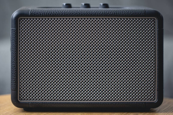 Square music speaker, metallic mesh texture close-up. Audio equipment and digital device.
