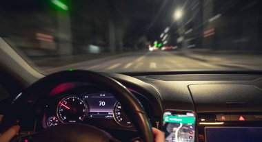 Araba direksiyonu ve gece yolu manzarası, yakın plan. Şehirde gece sürüşü.