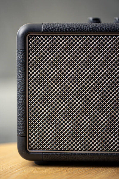 Square music speaker, metallic mesh texture close-up. Audio equipment and digital device.
