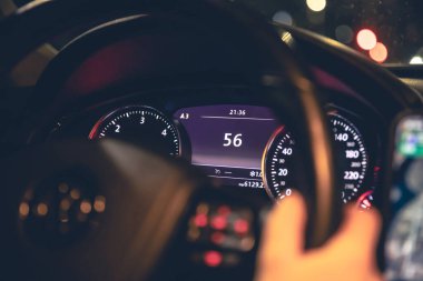 Hız göstergesi ve kadınların elleri geceleyin bir arabanın direksiyonunda, yakın plan..