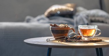 Çay seremonisi, bir bardak siyah çay ve bulanık arka planda çaydanlık. Ahşap bir masada tarçınlı sıcak kokulu çay. Boşluğu kopyala.