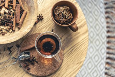 Bir fincan taze siyah çay, ahşap masada değişik baharatlar. Üst Manzara. Bir fincan çay, çay için baharat..