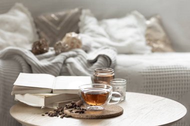 Odada bir fincan çay, kitaplar ve mumlarla ev kompozisyonu. Samimi bir ev geçmişi var. Boşluğu kopyala.