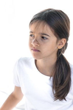 Beyaz bir arka planda üzgün, tatminsiz veya hayal kırıklığına uğramış bir genç kız. Gençlik duyguları, yüz ifadesi..