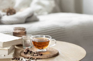 Odada bir fincan çay, kitaplar ve mumlarla ev kompozisyonu. Samimi bir ev geçmişi var. Boşluğu kopyala.