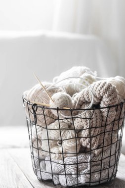Yuva konforlu, ahşap bir masada siyah bir sepetin içinde örgü ipliği. Rahatlık ve hobi. Arka plan yakın plan. Yüksek kalite fotoğraf
