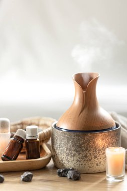 Hava nemlendirici ve aroma yağlı spa kompozisyonu. Temel yağ aroması yayıcı nemlendirici havadaki su maddelerini dağıtıyor..
