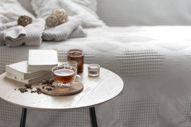 Odada bir fincan çay, kitaplar ve mumlarla ev kompozisyonu. Samimi bir ev geçmişi var. Boşluğu kopyala.
