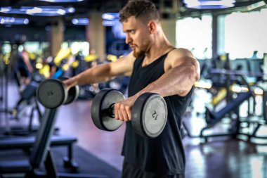 Sporcu salıncakta dambıllarla triseps sallıyor. Sağlıklı spor yaşam tarzı. Yüksek kalite fotoğraf