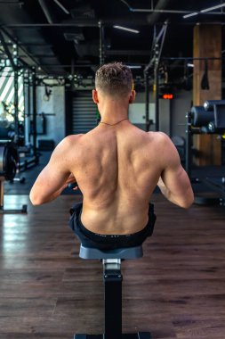 Spor salonunda sırtı çıplak bir sporcu kaslarını şişiriyor. Spor yaşam tarzı. - Evet. Yüksek kalite fotoğraf