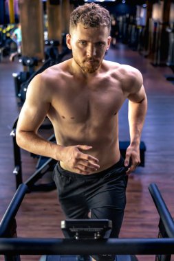 Spor salonunda koşu bandında bir sporcu. Spor salonundaki gömleksiz adam. Spor yaşam tarzı. Yüksek kalite fotoğraf