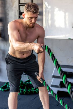 Ahlete çapraz halatla triseps egzersizleri yapıyor. Hobiler ve spor yaşam tarzı. - Evet. Yüksek kalite fotoğraf