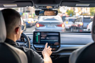A male driver drives at speed through the streets of the city, a view from inside the car.