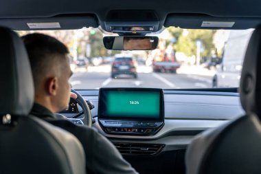 A male driver drives at speed through the streets of the city, a view from inside the car.