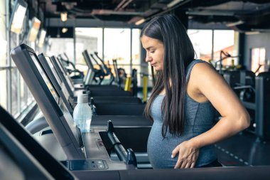 Spor salonunda koşu bandında hamile bir kadın. Sağlıklı spor yaşam tarzı. - Evet. Yüksek kalite fotoğraf