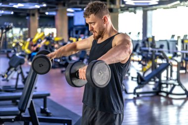 Sporcu salıncakta dambıllarla triseps sallıyor. Sağlıklı spor yaşam tarzı. Yüksek kalite fotoğraf