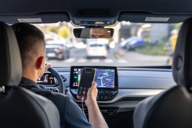 A male driver drives at speed through the streets of the city, a view from inside the car.