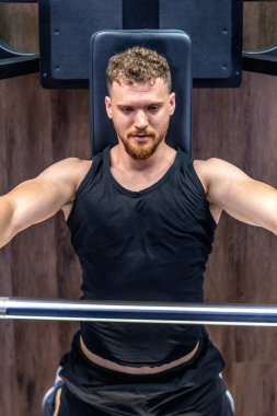 Spor salonundaki bir sporcu halterle trisepsi sallıyor. Spor yaşam tarzı. Spor hobileri ve sağlık. - Evet. Yüksek kalite fotoğraf